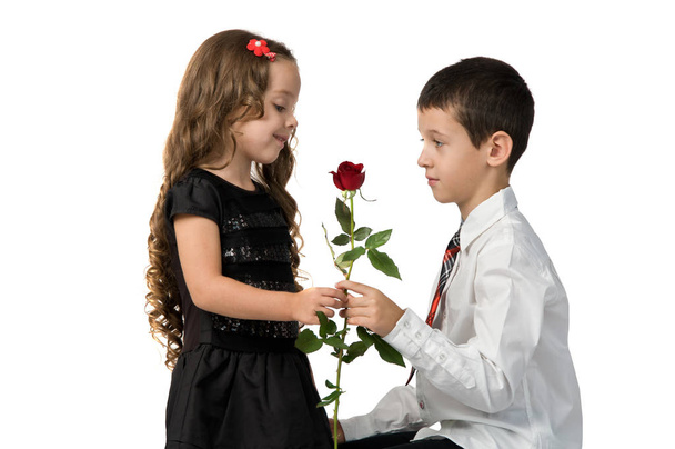 Il bambino dà una rosa rossa alla fidanzata. rapporto tra
  - Foto, immagini