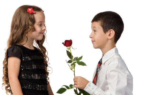 σχέση μεταξύ των μικρών παιδιών. ένα κορίτσι αγόρι δίνει στα λουλούδια. - Φωτογραφία, εικόνα