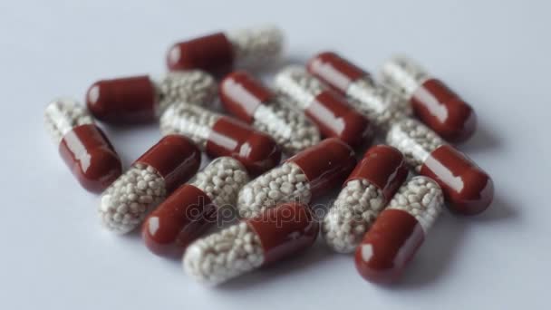 Pilules médicales placées sur la table tournante, prises avec fond blanc sans couture
 - Séquence, vidéo
