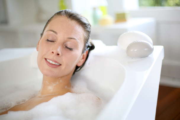 Woman relaxing in bathtub with eyes closed - Valokuva, kuva