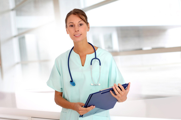 Portrait of beautiful nurse standing in hospital - Фото, изображение