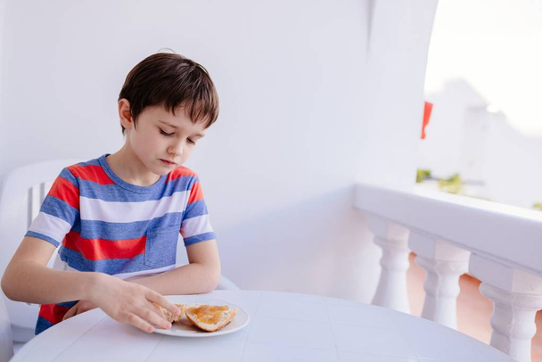 Jongetje eet stokbrood met jam - Foto, afbeelding