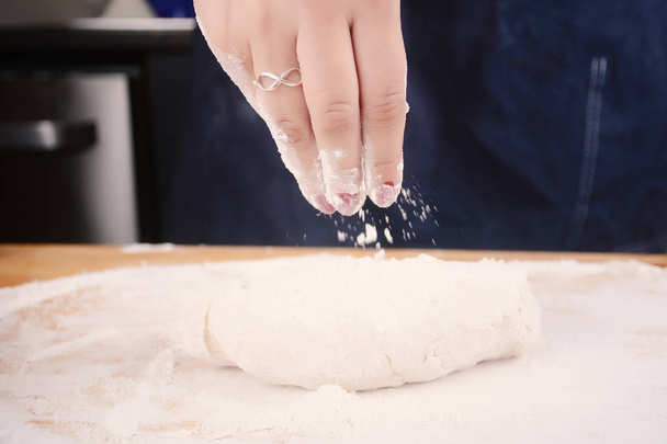 Woman hand adding flour to dough. - 写真・画像