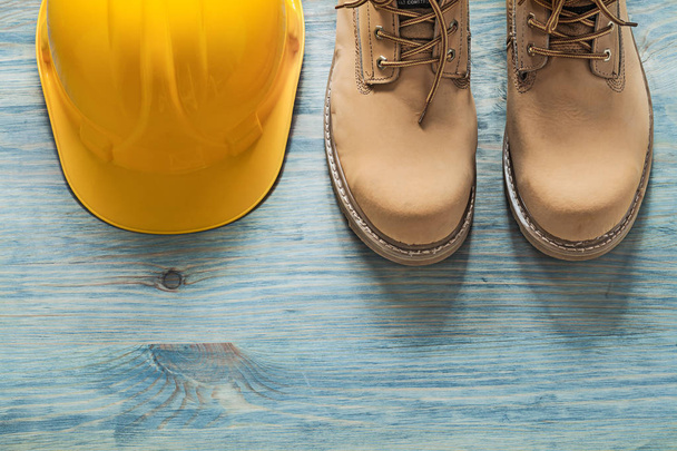 Pair of working boots building helmet on wooden board constructi - Photo, Image