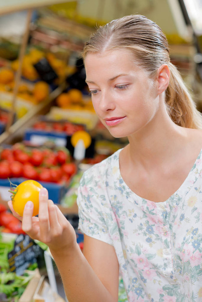 Closeup of lady holding a yellow tomato - Photo, image