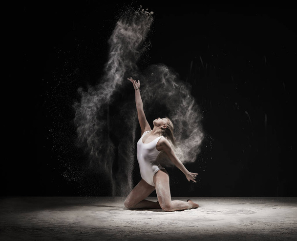 Woman in white dust cloud streches up gracefully - Photo, image