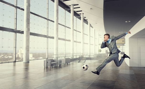 Playing football in office . Mixed media - Foto, afbeelding