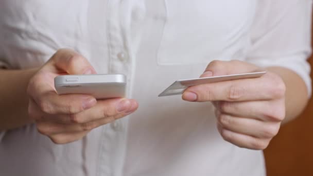 Mains tenant une carte de crédit et utilisant un téléphone intelligent mobile
 - Séquence, vidéo