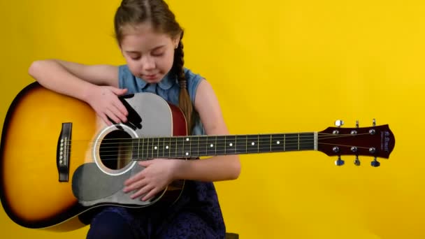 Blondes Mädchen blaue Augen spielt Gitarre - Filmmaterial, Video