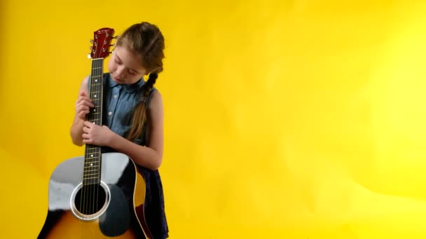 Μπλε μάτια ξανθιά κοπέλα παίζει κιθάρα - Πλάνα, βίντεο
