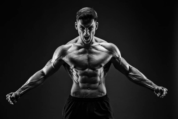 bodybuilder posing. Beautiful sporty guy male power. Fitness muscled man - Foto, Imagem
