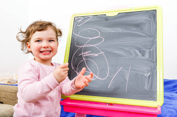 Little girl drawing on blackboard - Foto, immagini