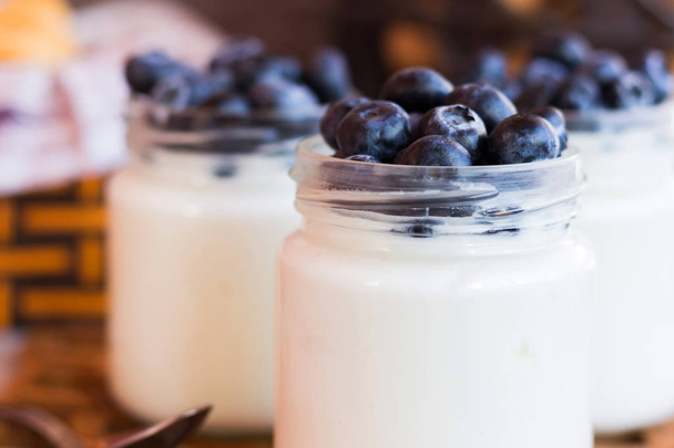 yogurt with blueberries in a glass jar - Photo, Image