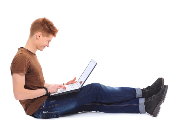 Successful happy man lying down o n floor using laptop - Foto, afbeelding