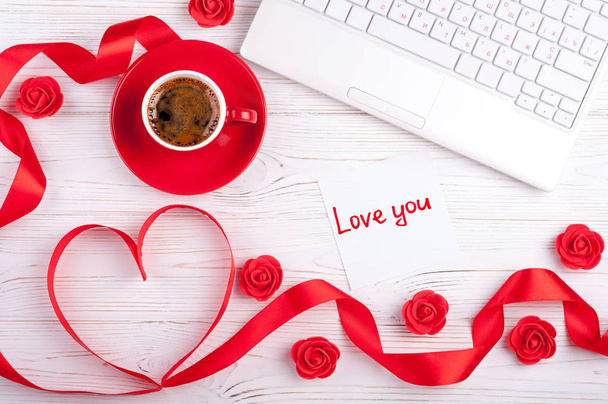 Fondo de San Valentín con corazón rojo, taza de café, portátil y rosas. Tarjeta de felicitación del día de San Valentín. Trabajo femenino
 - Foto, imagen