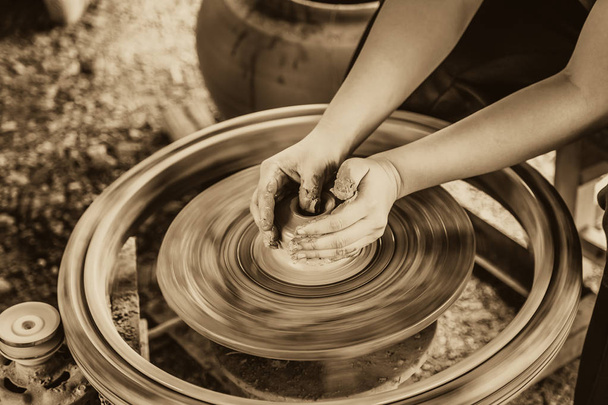 hand making making a clay or mud pot on a potters wheel art brown vintage color tone. - Photo, Image