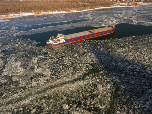Вантажний корабель на крижаній річці взимку
. - Фото, зображення