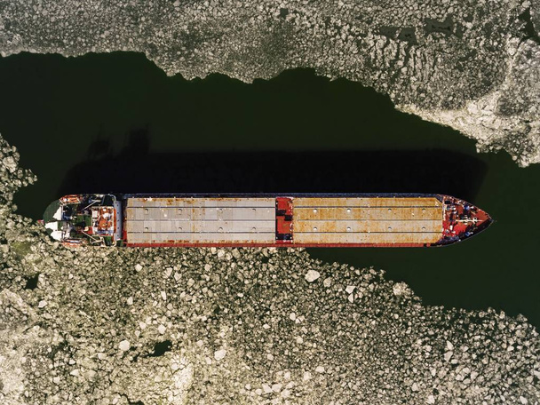 Cargo ship on the ice river in winter. - Фото, зображення