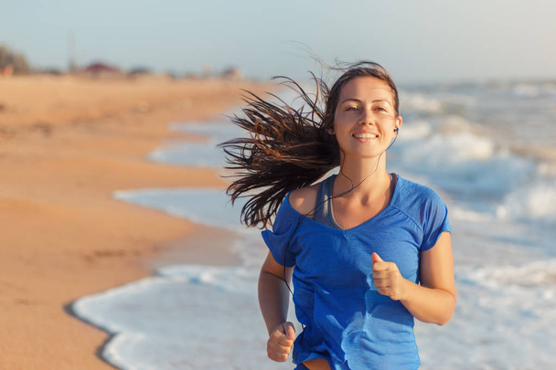 Фитнес-женщина бегает по пляжу - Фото, изображение
