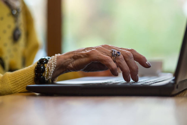 Senior dames hand en laptop. - Foto, afbeelding