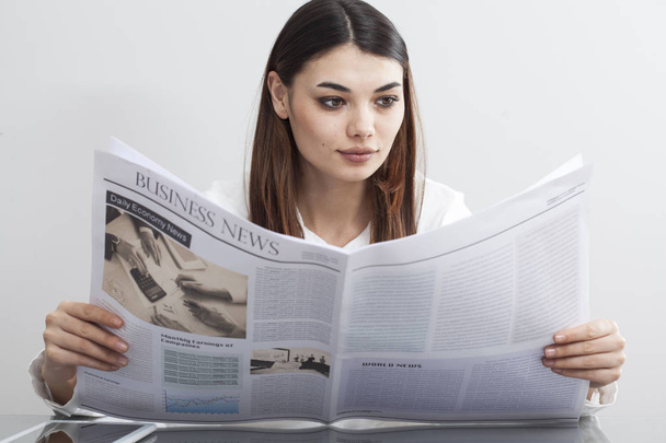 Empresaria leyendo periódico sobre fondo gris
 - Foto, imagen