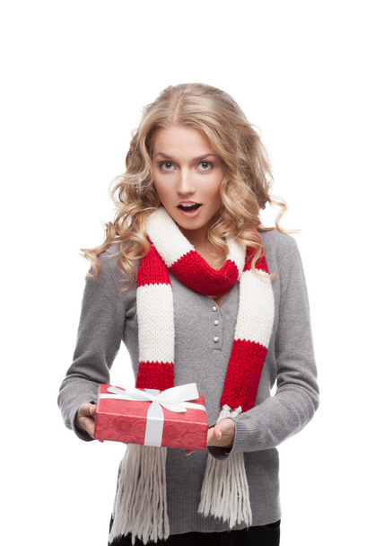 Young surprised woman holding christmas gift - 写真・画像
