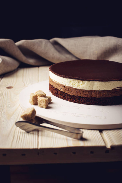 köstlicher dreilagiger Schokoladenkuchen steht auf einem runden Sockel - Foto, Bild