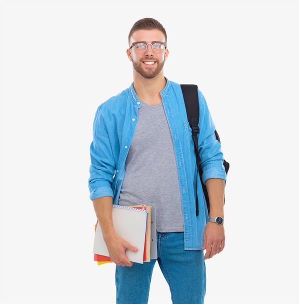 Male student with a school bag holding books isolated on white background - Фото, изображение