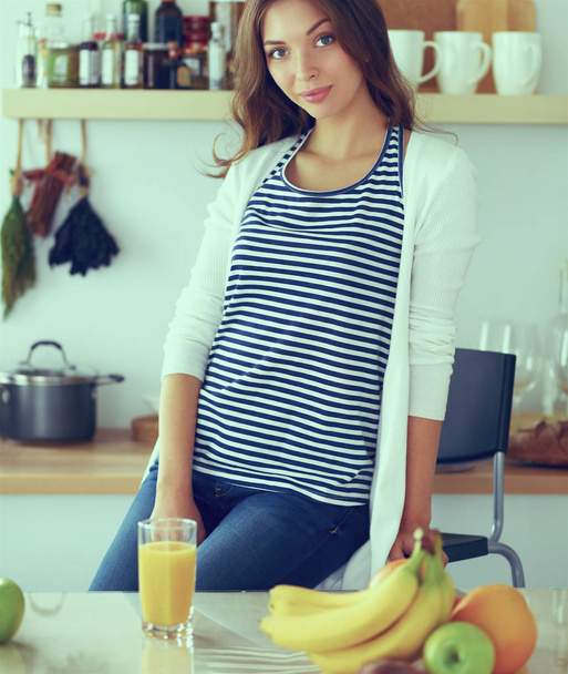 Young woman sitting near desk in the kitchen - Foto, immagini