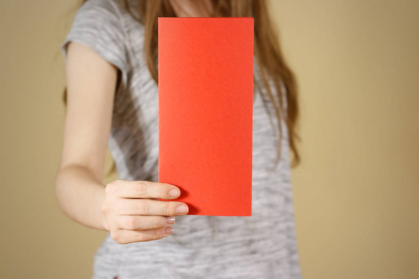 Girl showing blank red flyer brochure booklet. Leaflet presentat - Foto, Imagen