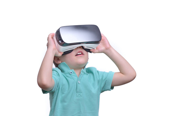 Удивительный подросток в очках виртуальной реальности, смотрящий фильмы или играющий в видеоигры, изолированный на белом. Удивлен, что подросток смотрит в очки виртуальной реальности. Эмоциональный портрет ребенка, испытывающего 3D гаджет
 - Фото, изображение