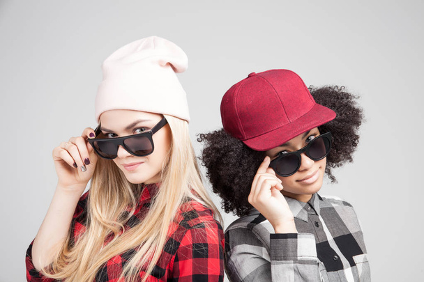 Studio lifestyle portrait of two best friends hipster girls going crazy and having great time together. Isolated on white background. - Foto, Bild