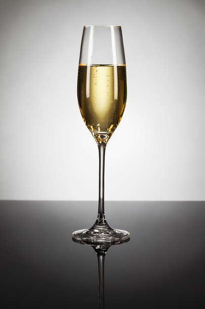 Glass of champagne on a mirror - Photo, Image