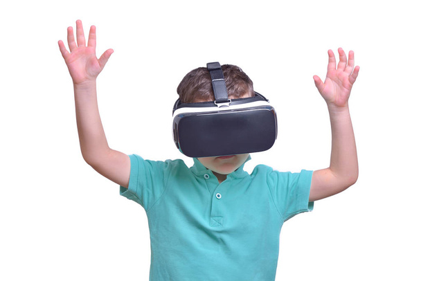 Amazed teen boy wearing virtual reality goggles watching movies or playing video games, isolated on white. Surprised teenager looking in VR glasses. Emotional portrait of child experiencing 3D gadget - Zdjęcie, obraz