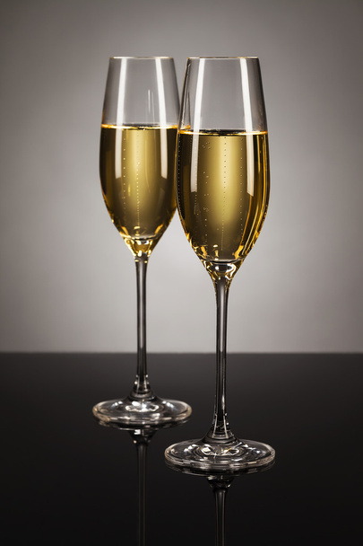 Two glasses of champagne on a mirror - Φωτογραφία, εικόνα