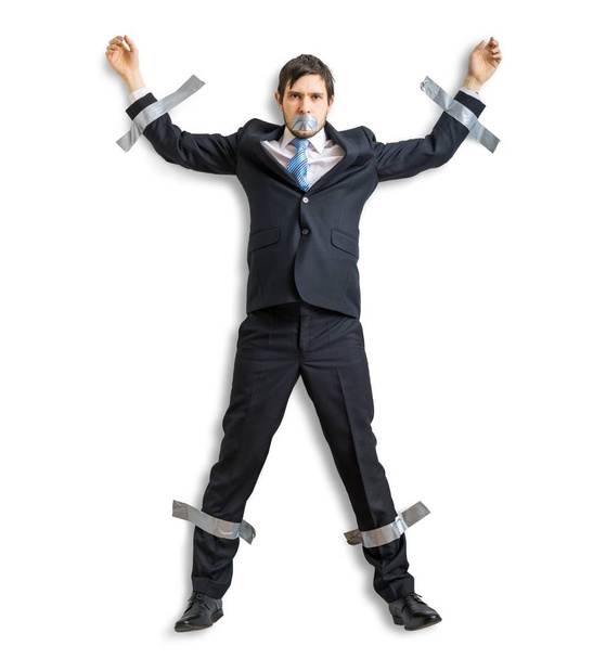 Бізнесмен у костюмі прикріплений до стіни скотчем. Ізольовані на білому тлі
. - Фото, зображення