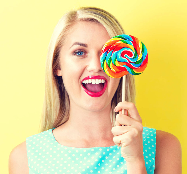 Young woman holding a lollipop - Фото, изображение
