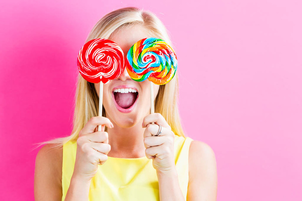 Young woman eating a lollipop - Фото, зображення
