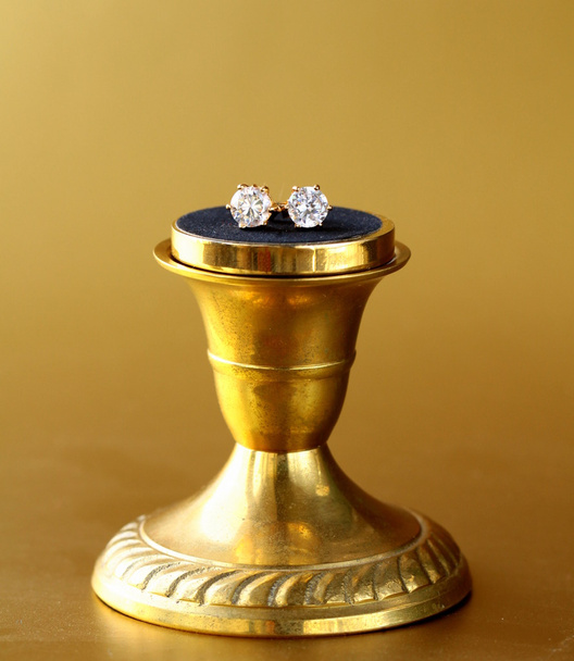 Золотые серьги с бриллиантами на золотом фоне
 - Фото, изображение