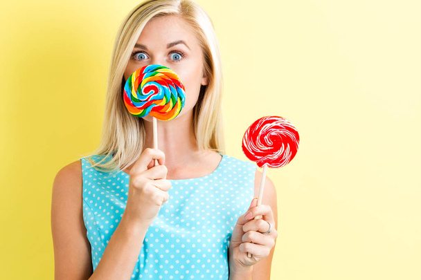 Young woman holding lollipops - Фото, изображение