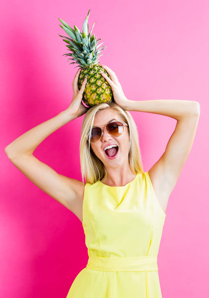 Happy young woman holding a pineapple - Φωτογραφία, εικόνα