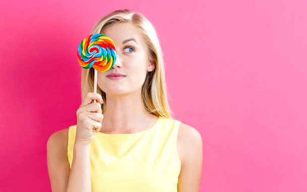 Young woman holding a lollipop - 写真・画像