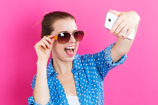 Young woman taking a selfie - Fotoğraf, Görsel
