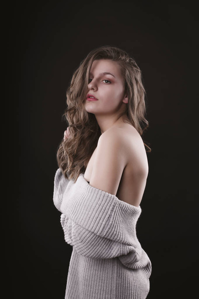 Zmysłowe woman młoda pozowanie w sweter z nagie ramiona - Zdjęcie, obraz