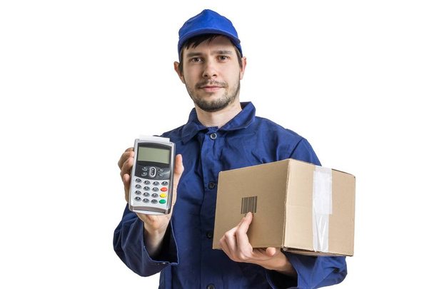Shipment and package delivery concept. Young man holds cardboard box and payment terminal in hands. Isolated on white background. - Photo, Image