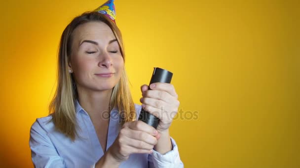 woman launches confetti on a yellow background slow motion - Footage, Video