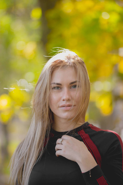 Retrato de joven atractiva hembra posando en el entrenamiento en el parque de otoño, teleobjetivo
 - Foto, imagen