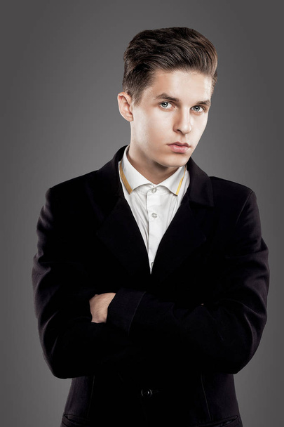 Young trendy man. Black suite, gray background. Portrait - Fotografie, Obrázek