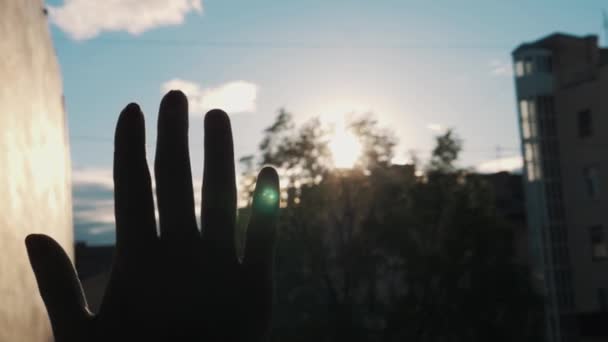Slowmotion κοντινό σιλουέτα της γυναίκας μπλοκάρει ήλιο με την παλάμη του χεριού, εκτός - Πλάνα, βίντεο