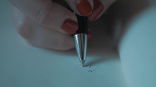 Close-up van tikje vrouw hand rode nagellak schrijven met pen op gewoon papier - Video